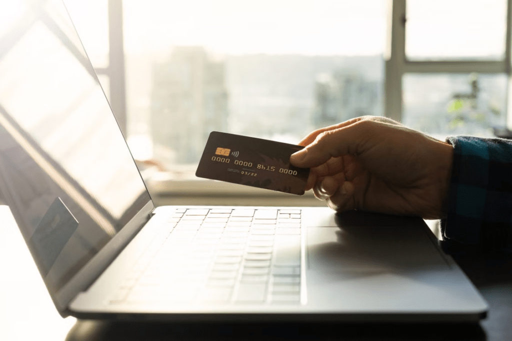 Online payment with a credit card and laptop representing saved payment information and shared-device privacy.