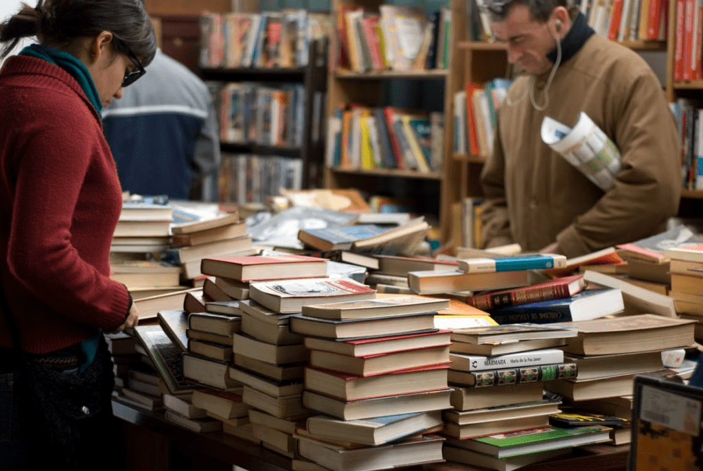Collector inspecting the condition of a used manga volume for cover wear, spine damage, and page quality.